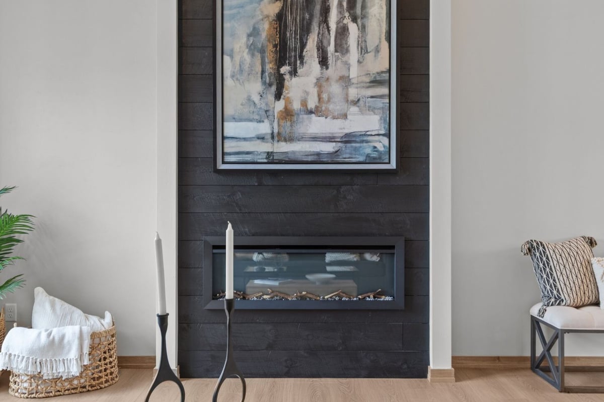 Close-up of fireplace feature wall with abstract art in a custom Kaukauna, WI home by Midwest Design Homes