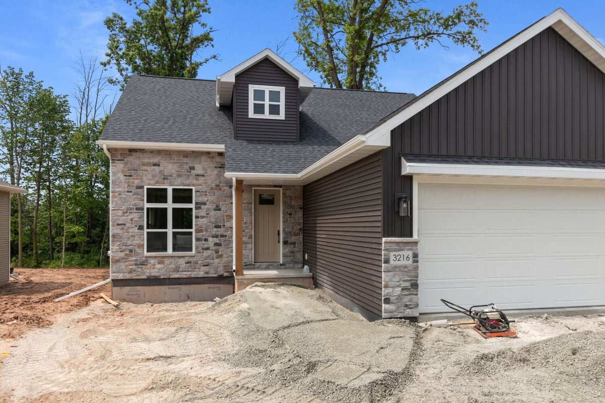 Entryway with stone façade and vertical siding in a Green Bay, WI custom home by Midwest Design Homes