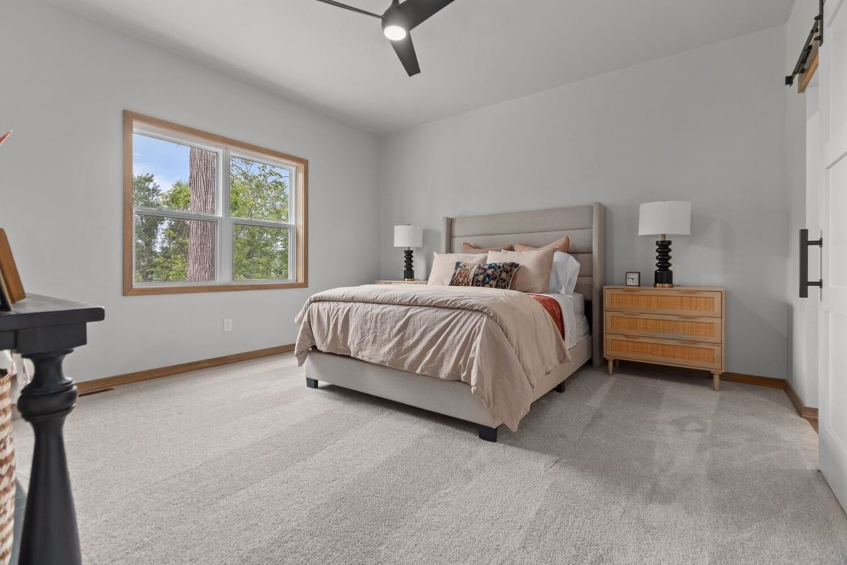 Light-filled primary bedroom with wooded views in a custom-built Wisconsin home by Midwest Design Homes