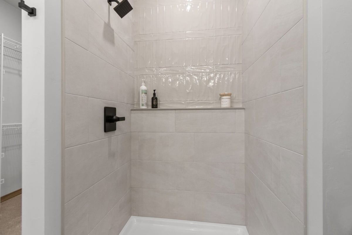 Sleek bathroom shower with built-in shelf in a custom Wisconsin home by Midwest Design Homes