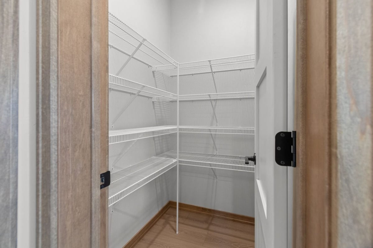 Walk-in kitchen pantry with wire shelving in a Harrison, WI custom home by Midwest Design Homes