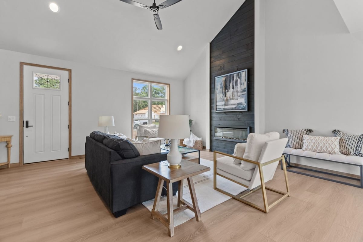 Welcoming front room featuring large windows and a black shiplap fireplace in a Neenah, WI custom home