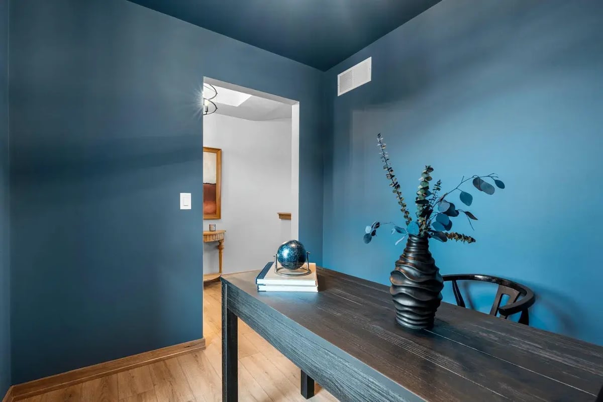 Bold blue home office with modern decor and wood accents located in the Fox Cities