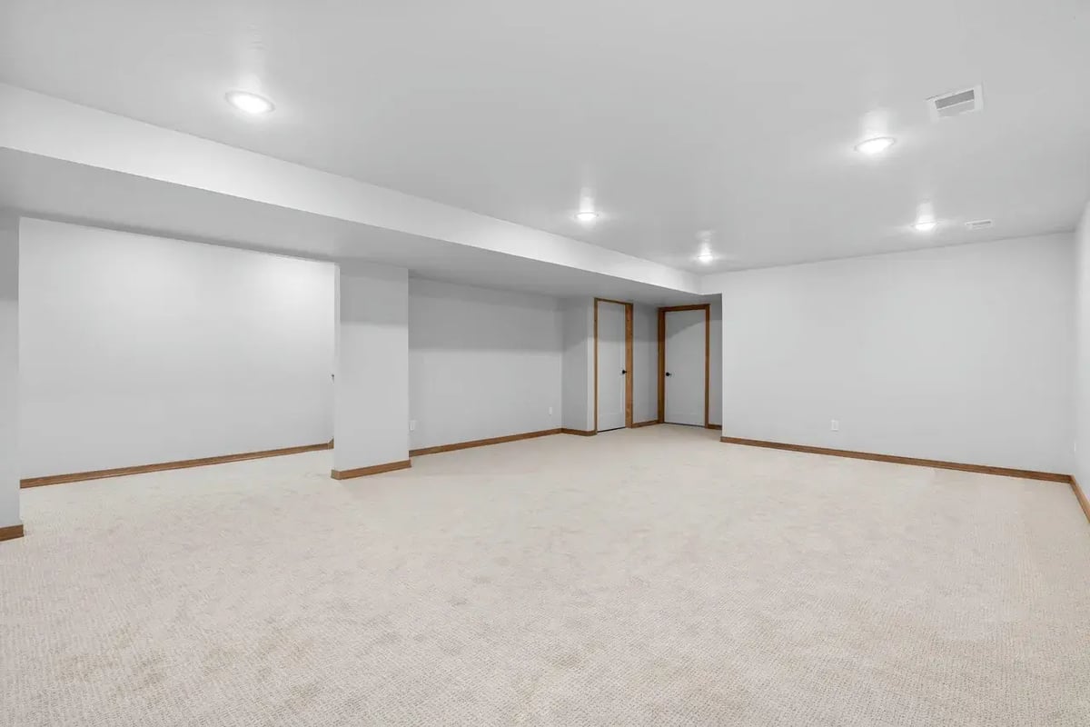 Finished basement in the Fox Cities with neutral carpet, recessed lighting, and white walls with natural wood trim