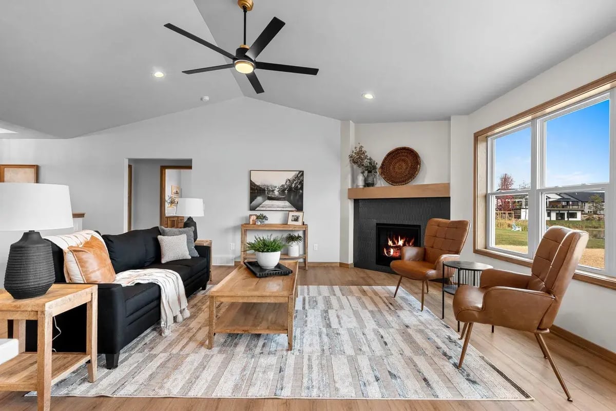 Modern living room with fireplace, wood accents, and large windows in a Fox Cities home