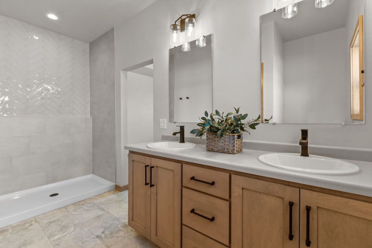 Bathroom with double vanity and wood cabinetry in a Midwest Design Homes custom home in Fremont, WI