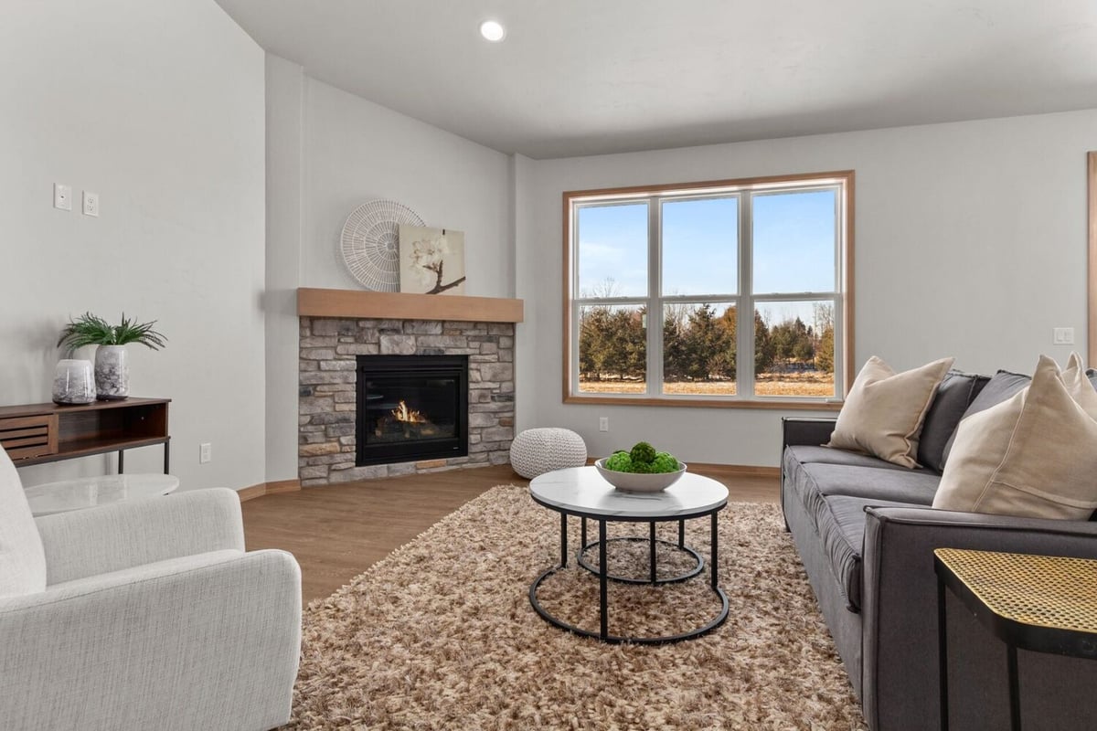 Cozy living room with fireplace and natural light by Midwest Design Homes in Greenville, WI