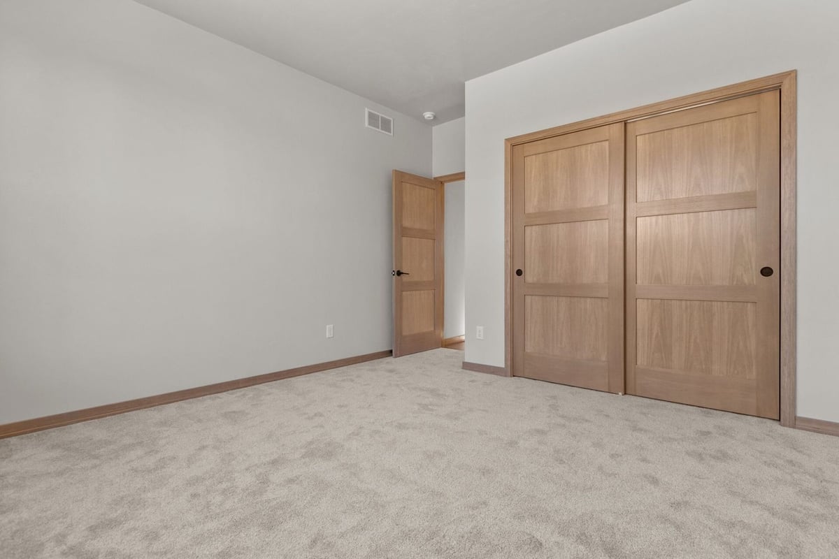 Custom home bedroom with oak closet doors built by Midwest Design Homes in Ellington, WI