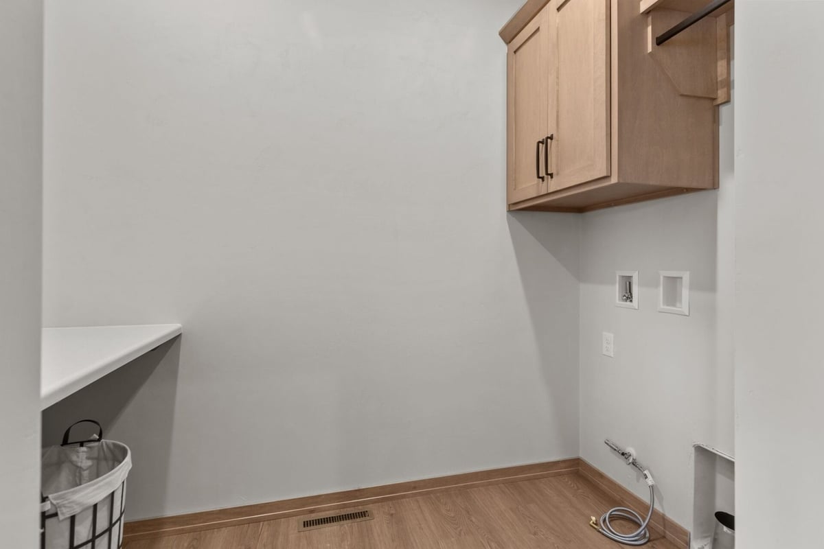 Laundry room with wood cabinets in a Midwest Design Homes custom home in Kaukauna, WI