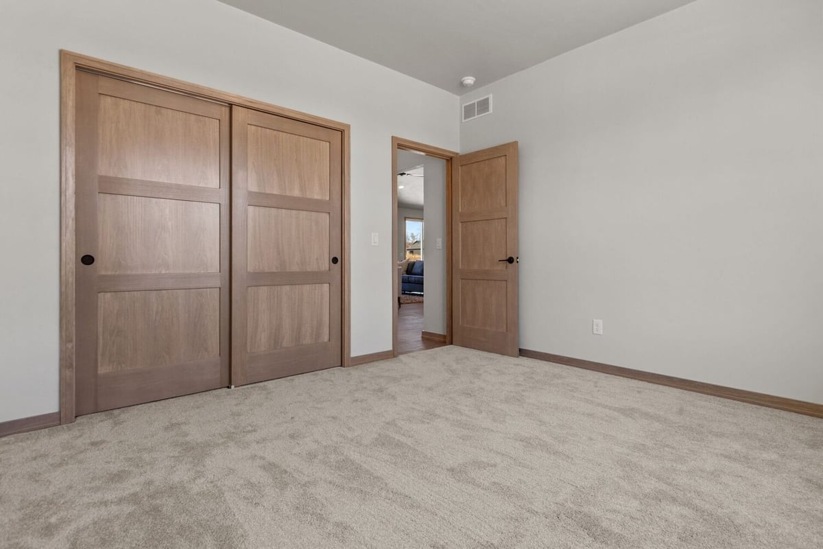 Spacious bedroom remodel with oak trim and closet in a Midwest Design Homes custom build in De Pere, WI