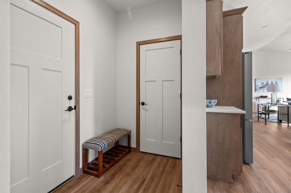 Entry foyer with bench, wood flooring, and interior doors, located in the Fox Cities