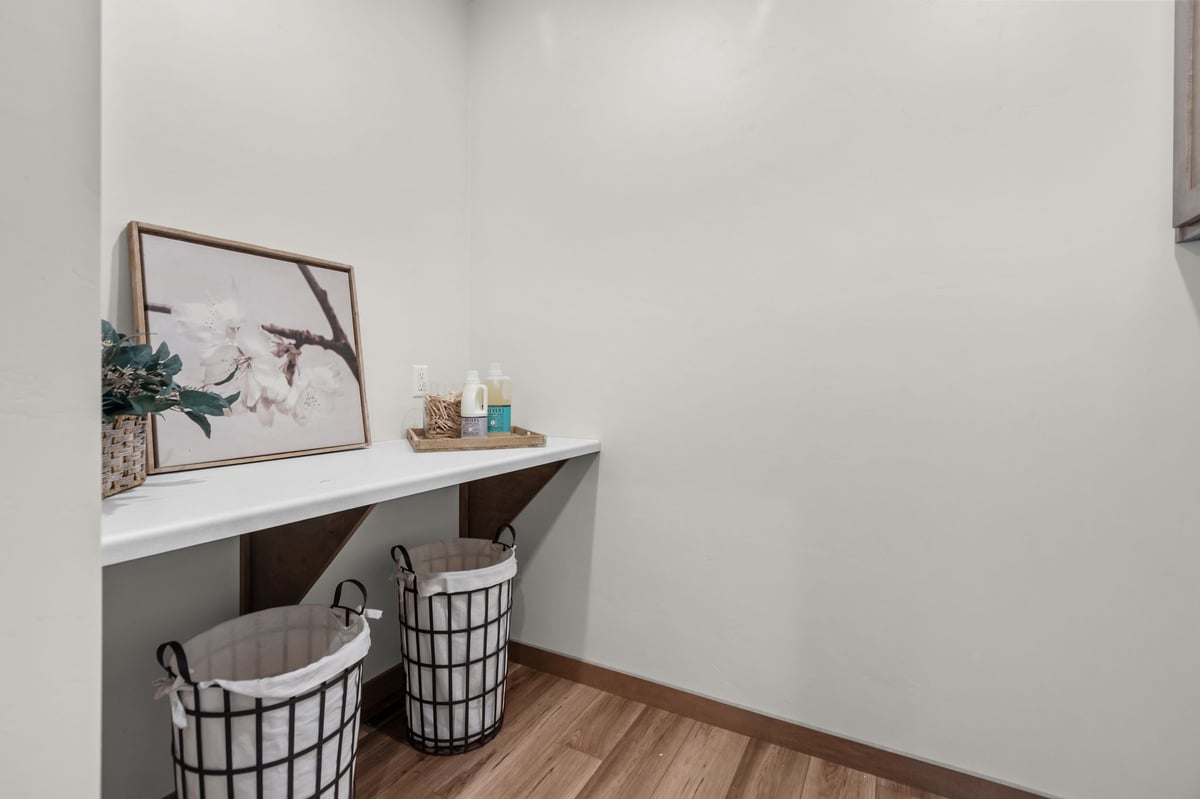 Laundry room counter with storage baskets, decor, and wood flooring, located in the Fox Cities