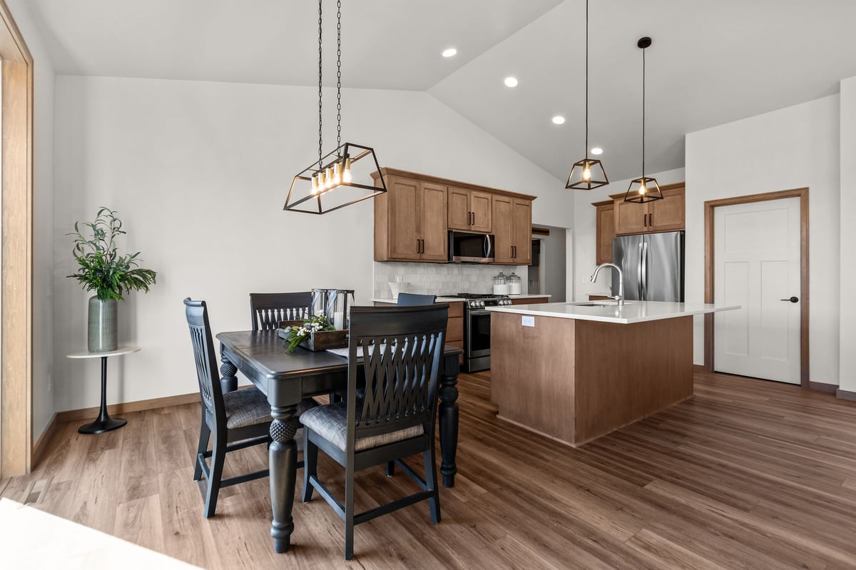 Open dining area with dark table, pendant lighting, and adjacent kitchen island, located in the Fox Cities