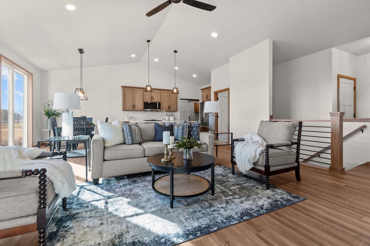 Open great room with living area, kitchen, vaulted ceiling, and modern lighting, located in the Fox Cities