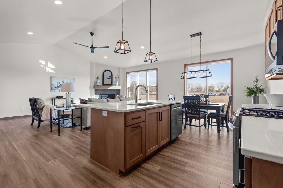 Open-concept kitchen with island, pendant lighting, dining area, and great room, located in the Fox Cities