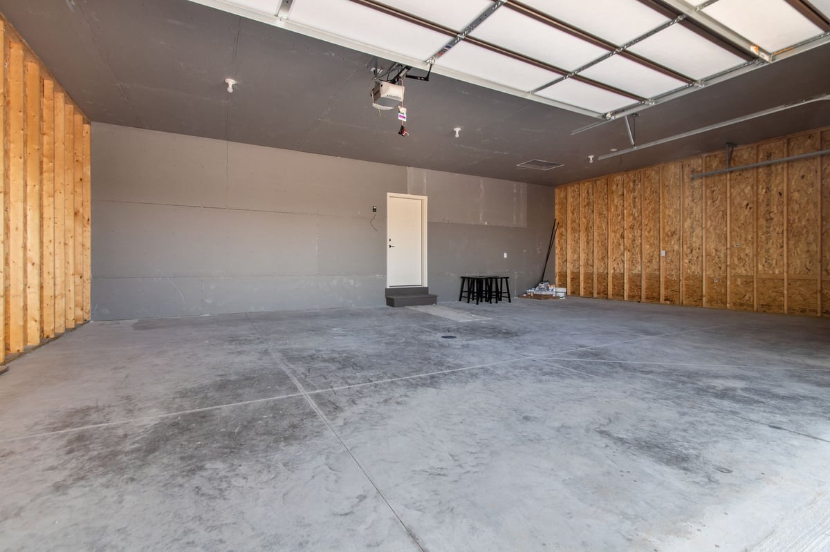Spacious three-car garage with concrete floors, drywall, and storage space, located in the Fox Cities