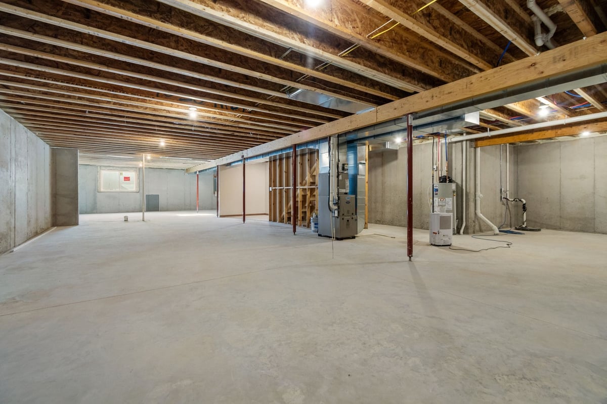 Unfinished basement with concrete floors, exposed beams, and mechanical systems, located in the Fox Cities