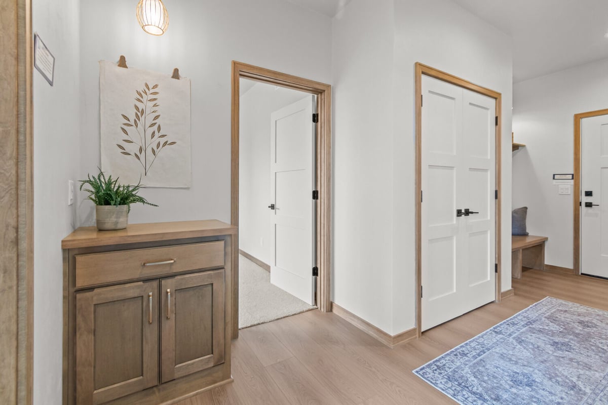 Bright custom-built hallway space featuring wood doors and storage cabinet by Midwest Design Homes in Neenah, WI