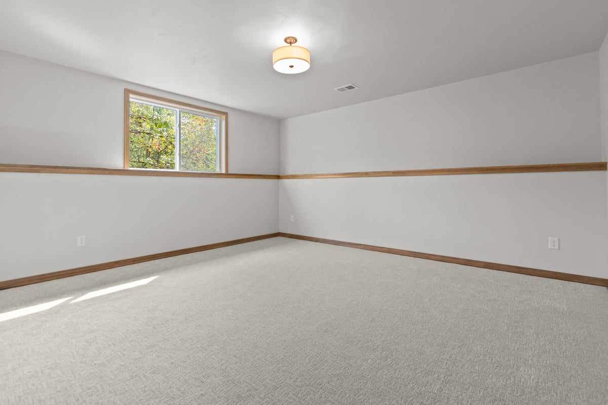 Large lower-level room with soft carpeting in a Wisconsin home by Midwest Design Homes