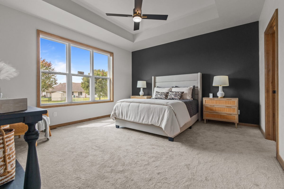 Master bedroom with dark accent wall and wood trim by Midwest Design Homes in Green Bay, WI