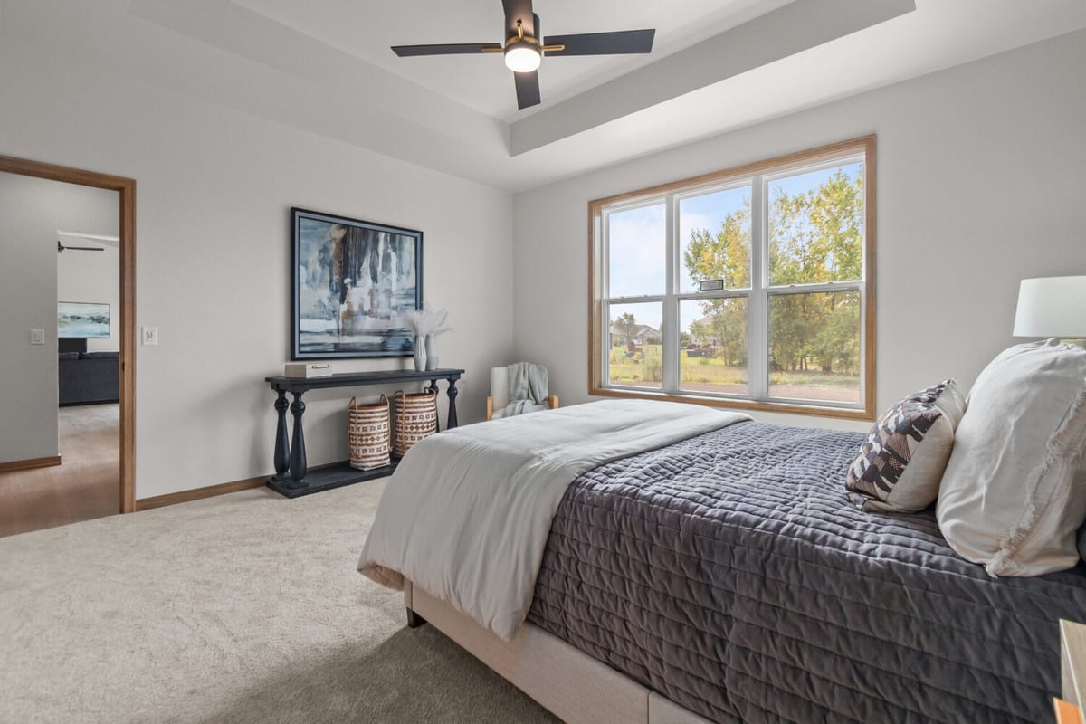 Master bedroom with large window and tray ceiling by Midwest Design Homes in Kaukauna, WI