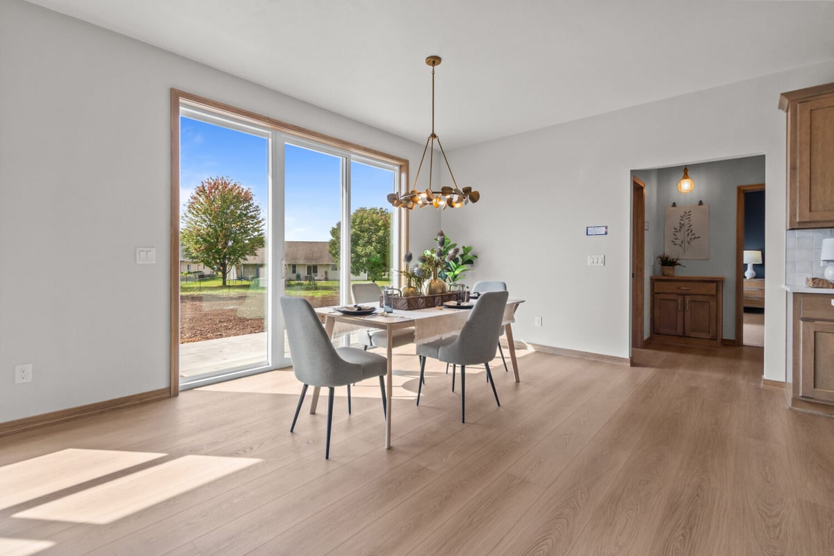 Modern dining area with gold chandelier by Midwest Design Homes in Ellington, WI