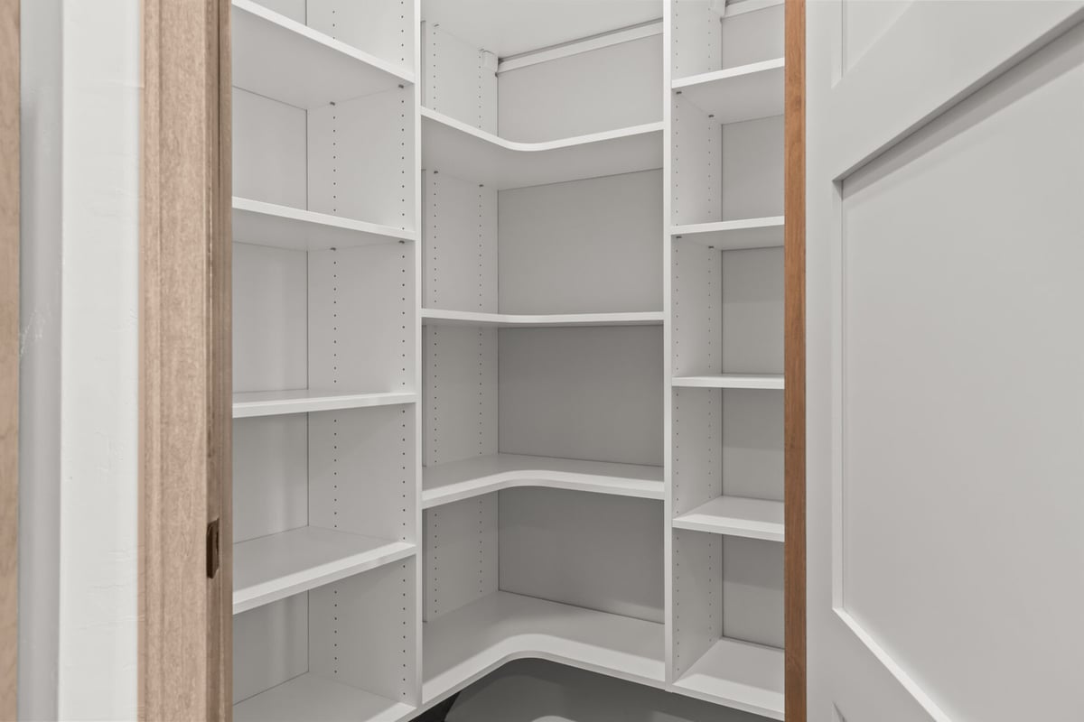 Organized storage pantry with built-in shelving by Midwest Design Homes in Neenah, WI