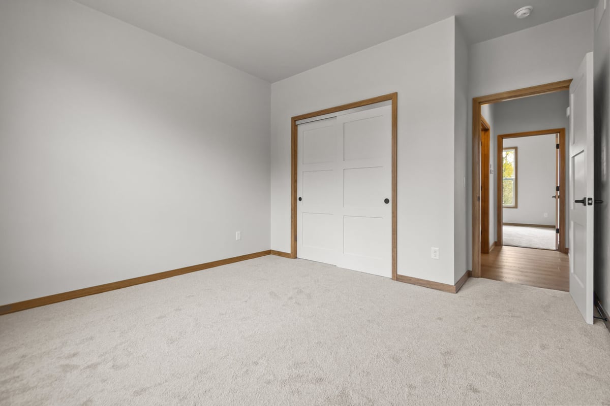 Spare bedroom with sliding closet doors and neutral tones by Midwest Design Homes in Ledgeview, WI