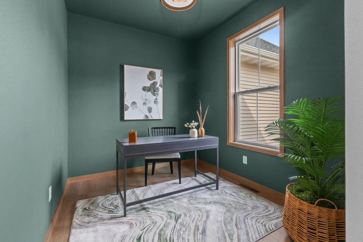 Stylish home office with green walls and natural light by Midwest Design Homes in Kaukauna, WI