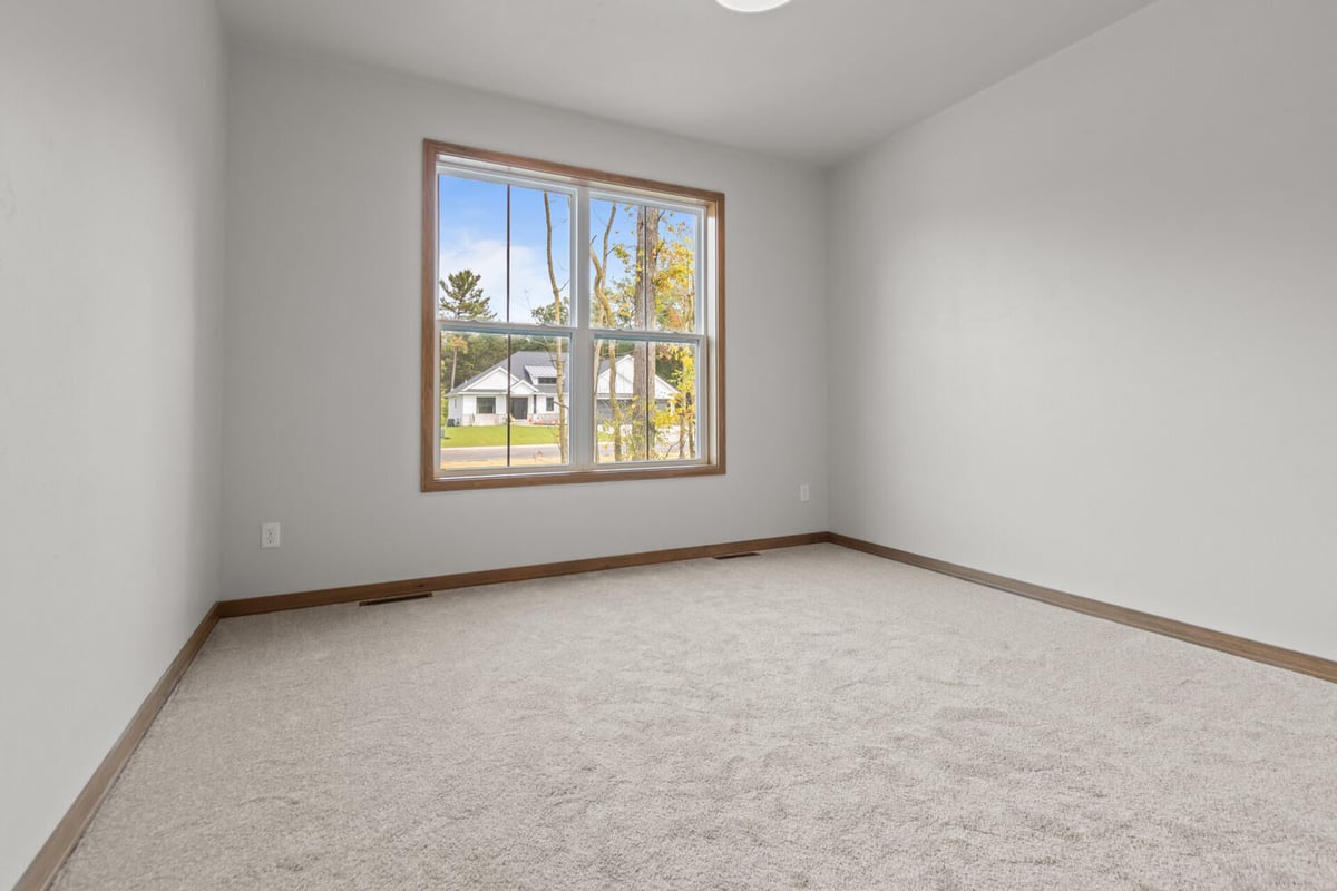 Sunlit secondary bedroom in a custom-built home by Midwest Design Homes in Neenah, WI
