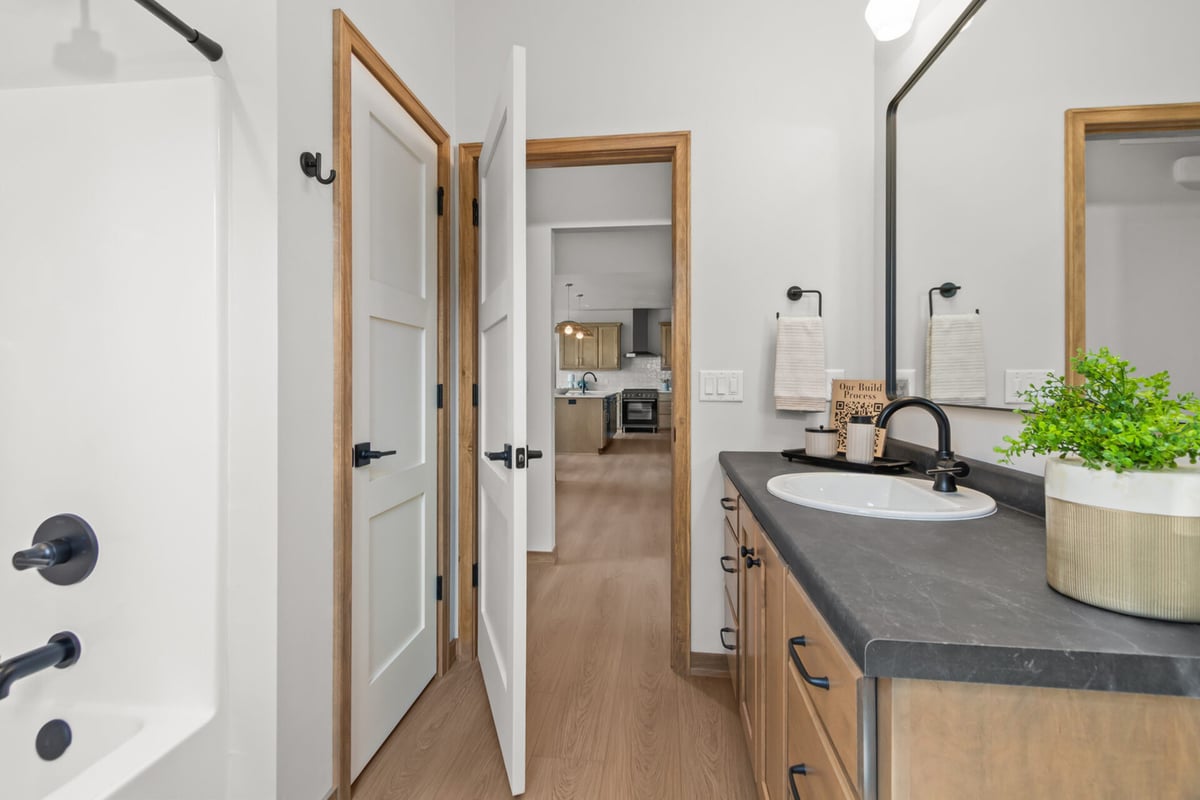Transitional bathroom with black faucet and mirror in a custom home by Midwest Design Homes in Bellevue, WI