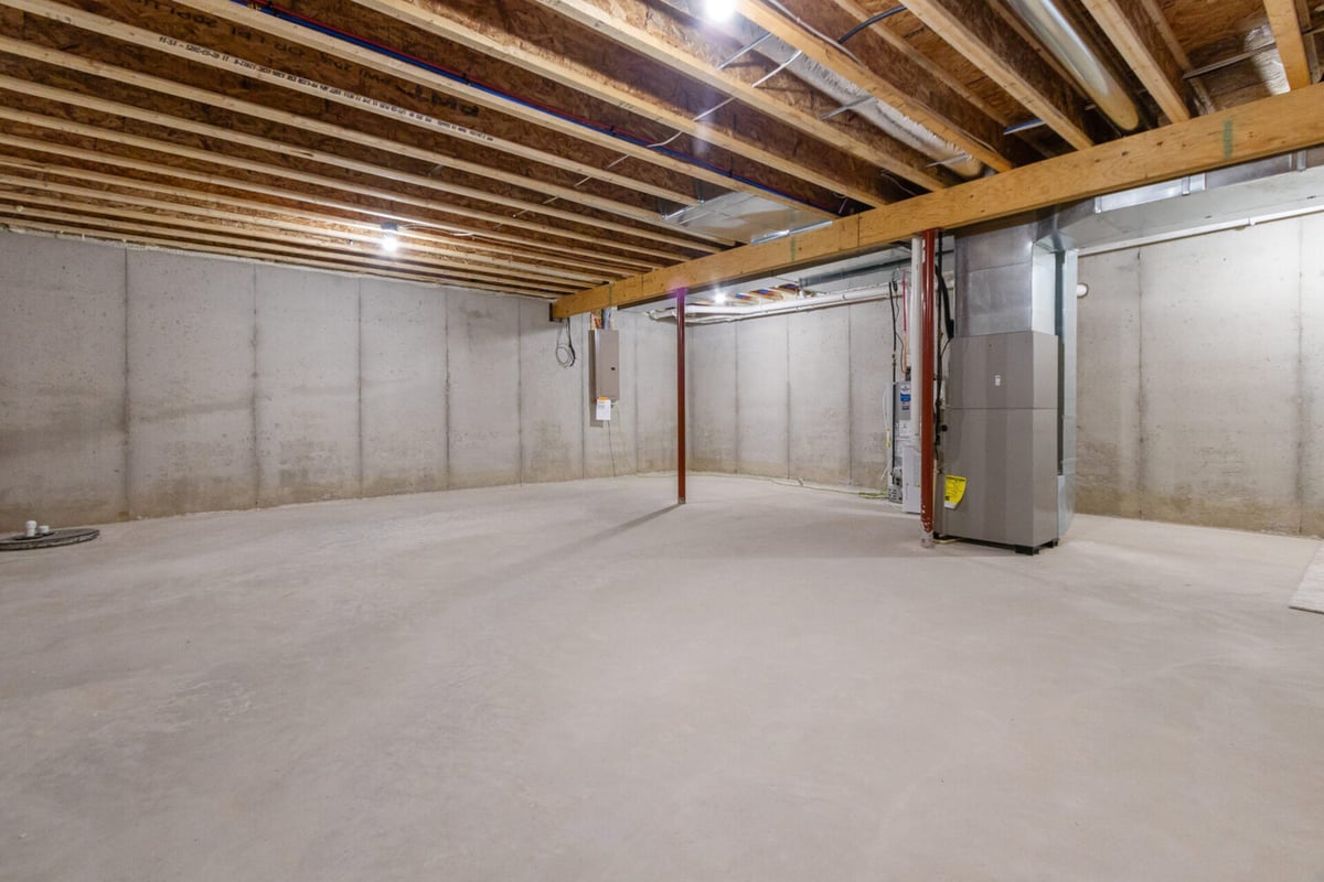 Unfinished basement with exposed ceiling and HVAC system by Midwest Design Homes in De Pere, WI