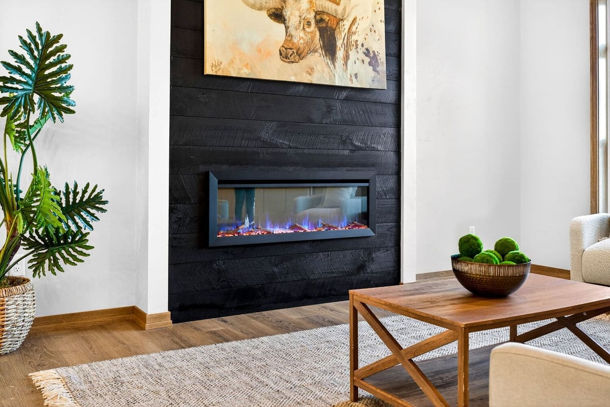 Contemporary living room with black shiplap fireplace, modern art, and wood coffee table in the Fox Cities