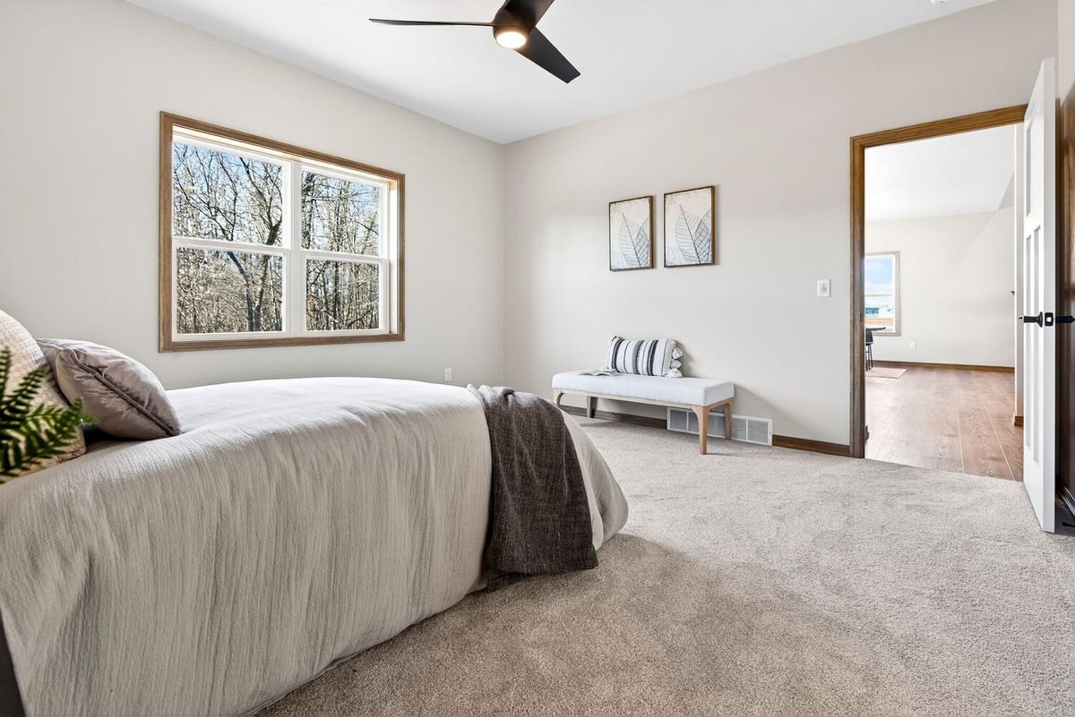 Cozy bedroom view with soft carpet, ceiling fan, and natural light in a Fox Cities home