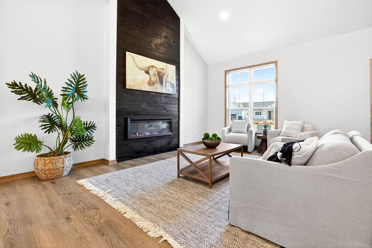 Cozy living room with black shiplap fireplace, neutral seating, wood floors, and modern decor in a Fox Cities home