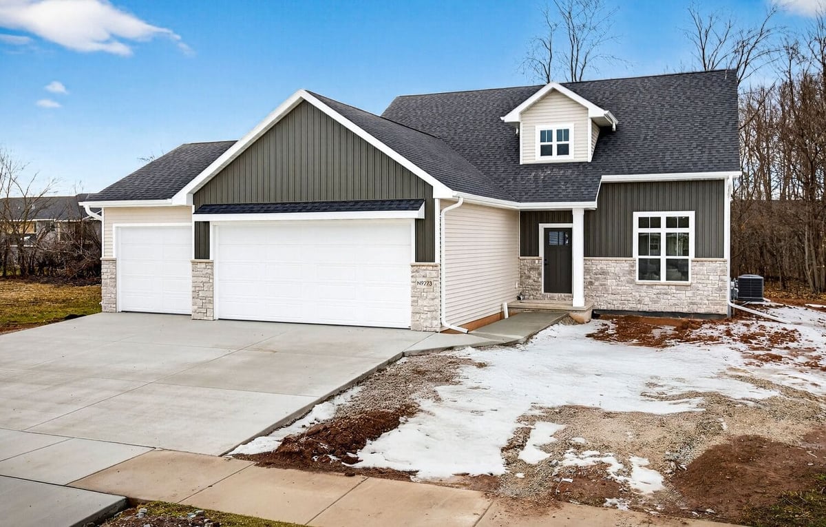 Exterior of a modern craftsman-style home with mixed siding, stone accents, and attached garage in the Fox Cities