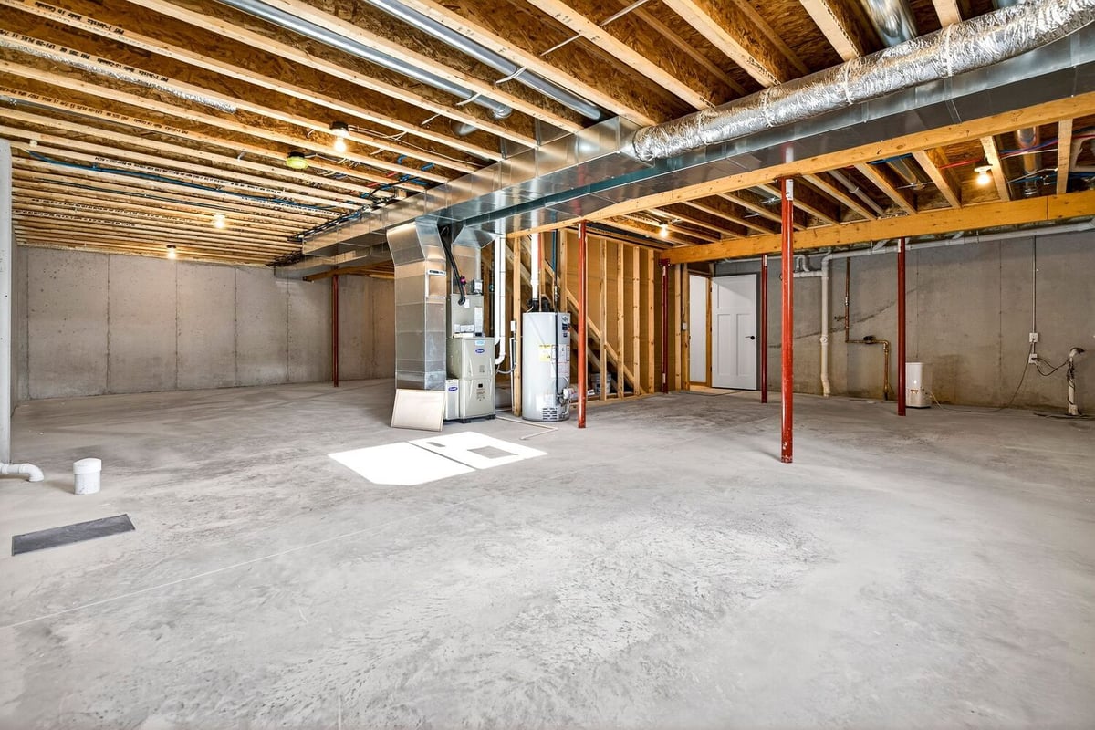 Large unfinished basement showing HVAC equipment, ductwork, and open layout in a Fox Cities home