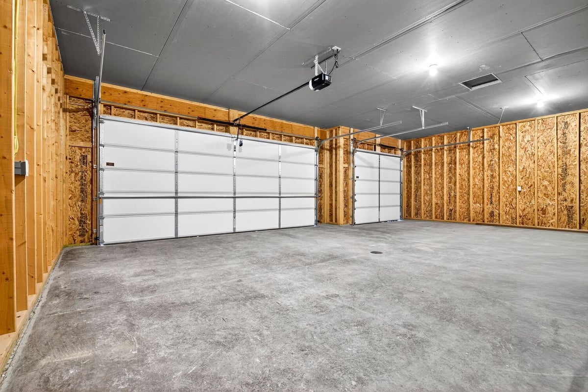Spacious unfinished garage with dual overhead doors and concrete floor, located in the Fox Cities