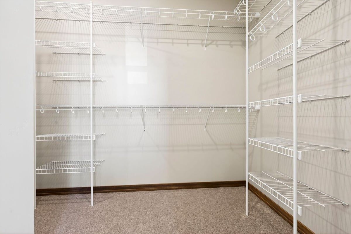 Walk-in closet with white wire shelving and carpeted floor in a Fox Cities home
