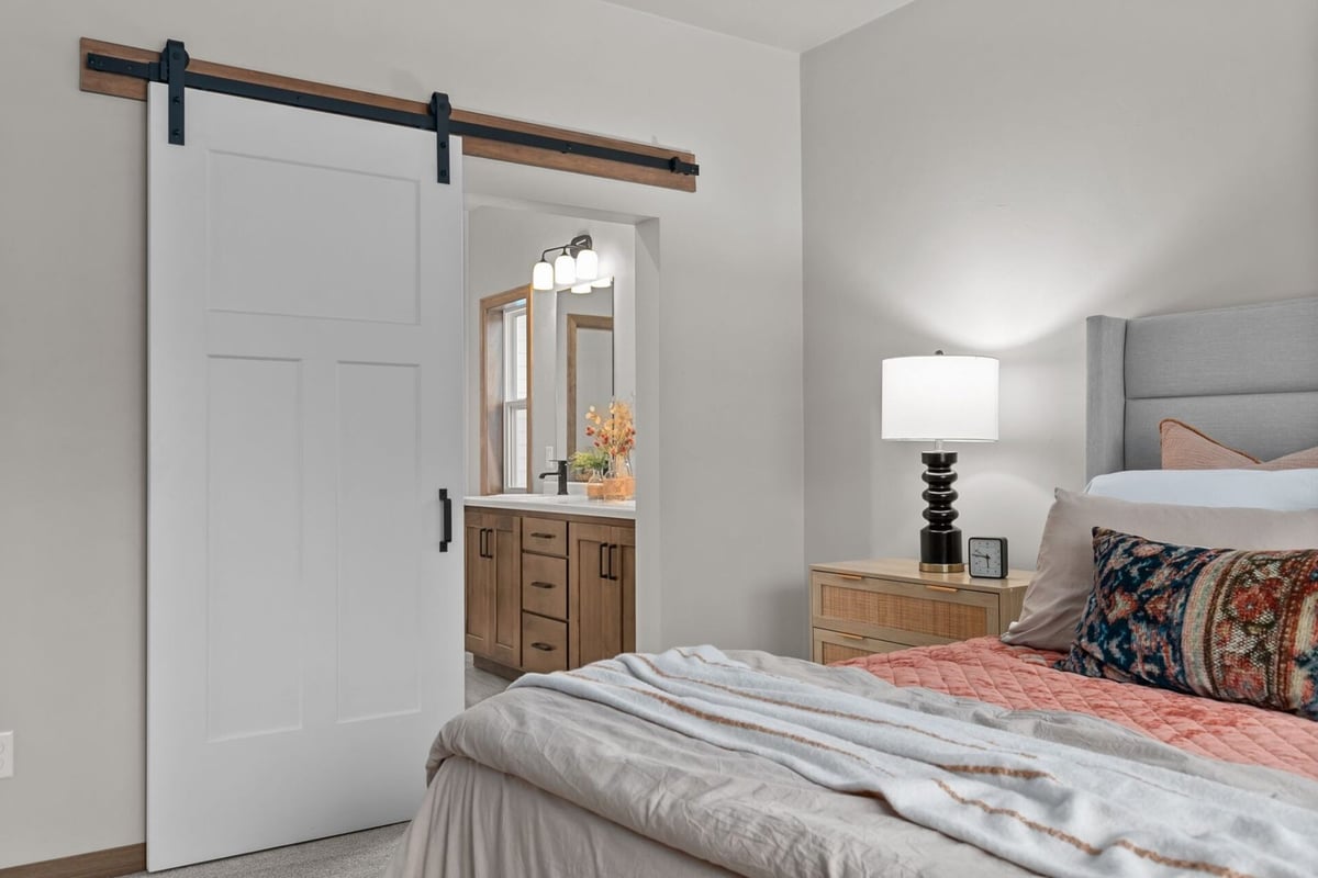Close-up of bedroom with barn door entry to ensuite in a De Pere, WI custom home by Midwest Design Homes