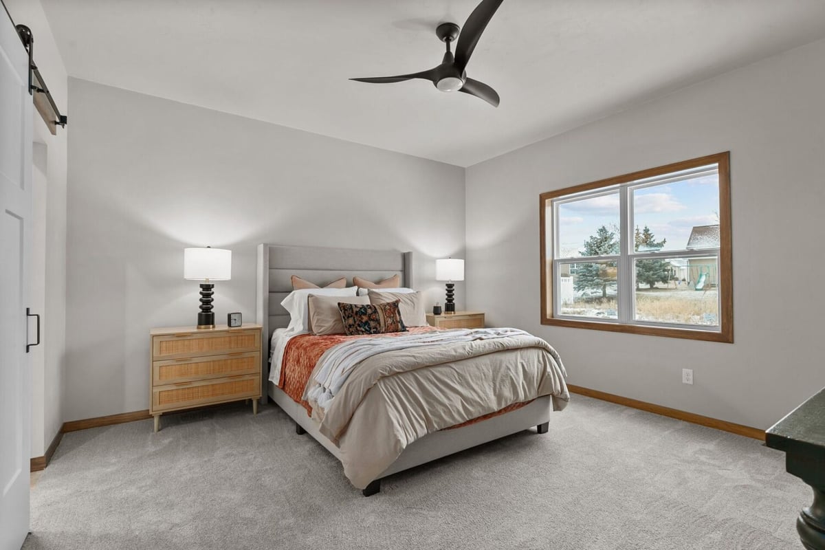 Cozy bedroom featuring large windows and neutral tones in a Kaukauna, WI custom home by Midwest Design Homes