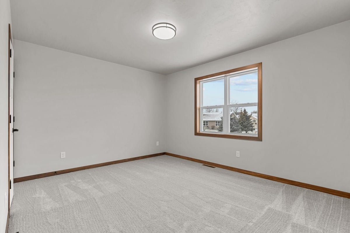 Custom home bedroom with new carpet and natural light by Midwest Design Homes in Harrison, WI