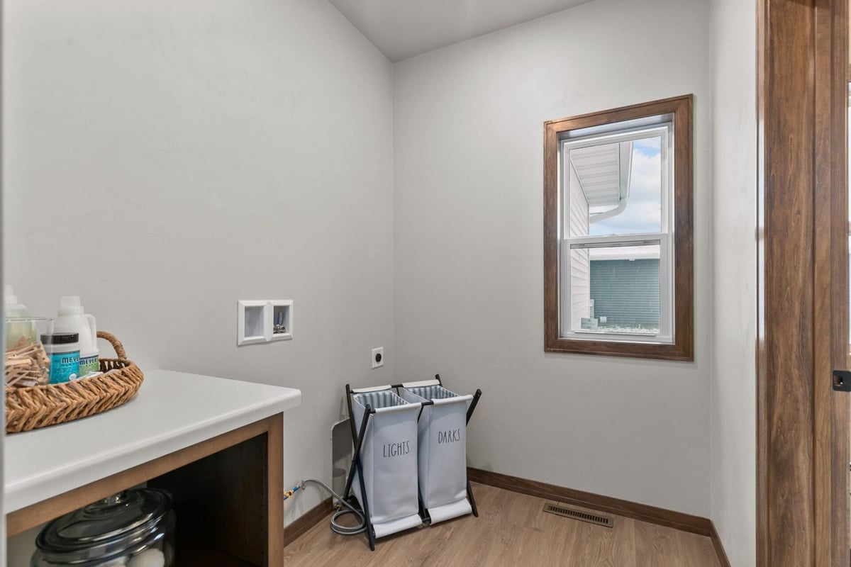 Laundry room with dual hamper setup in a custom home by Midwest Design Homes in Appleton, WI