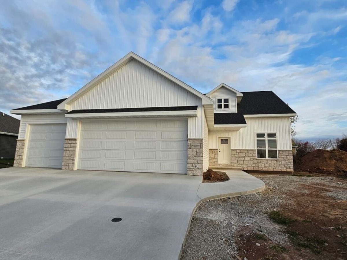Modern white custom home exterior with stone accents by Midwest Design Homes in Kaukauna, WI