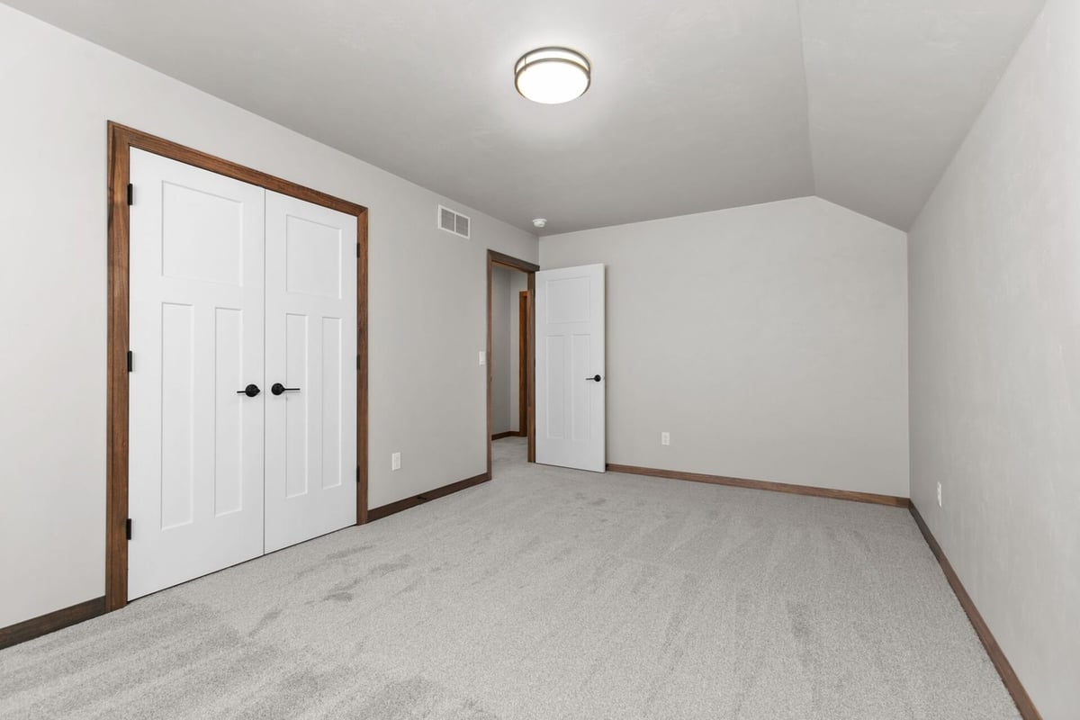 Spacious bedroom with clean lines and closet doors by Midwest Design Homes in Fremont, WI