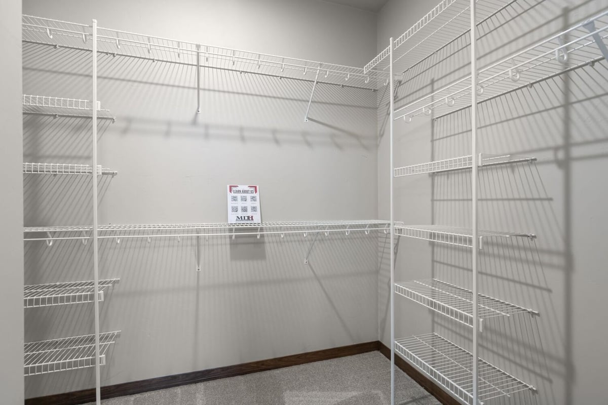 Spacious walk-in closet with wire shelving in a custom home by Midwest Design Homes in Ellington, WI