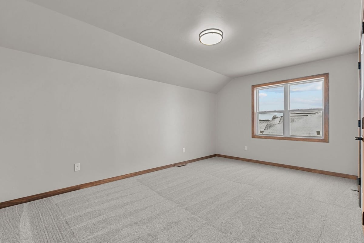 Upper-level bedroom with vaulted ceiling in a custom Wisconsin home by Midwest Design Homes