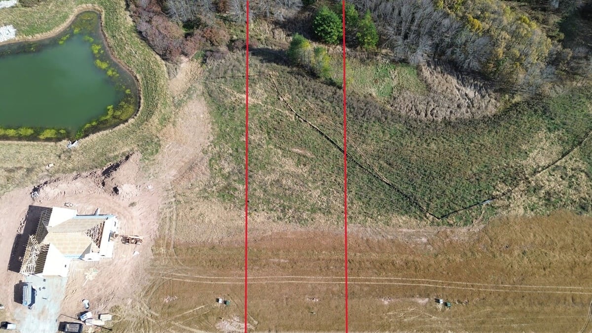 Aerial view of land for sale in De Pere, WI near pond and new home construction with marked lot lines