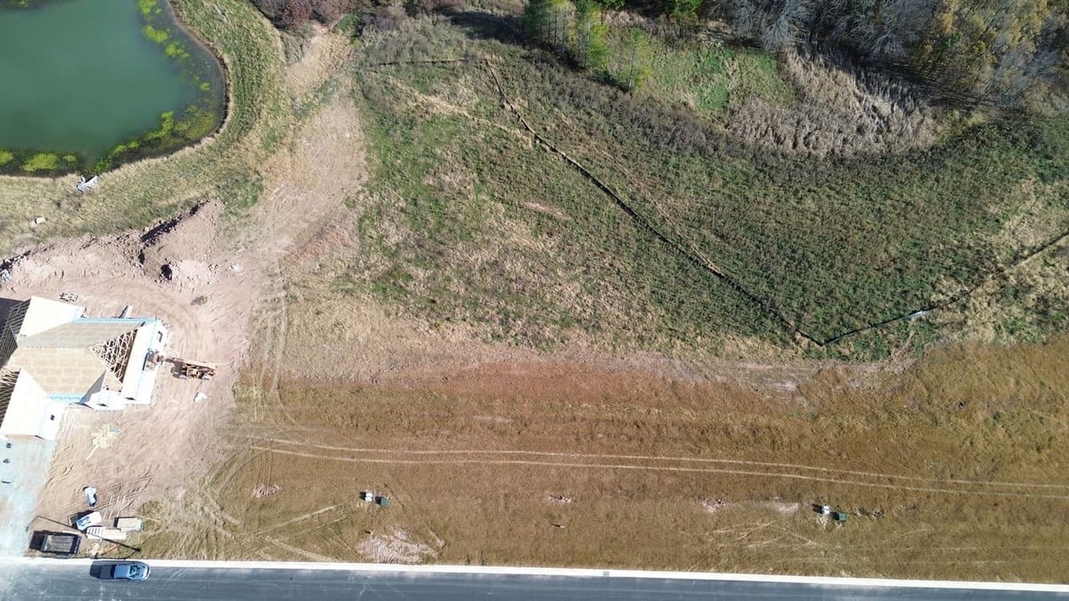 Aerial view of residential land for sale in De Pere, WI next to new construction home and open field