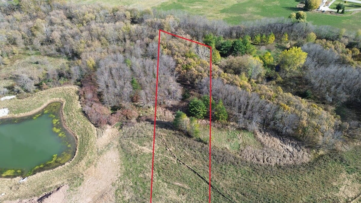 Aerial view of wooded land for sale in De Pere, WI with lot lines marked near pond